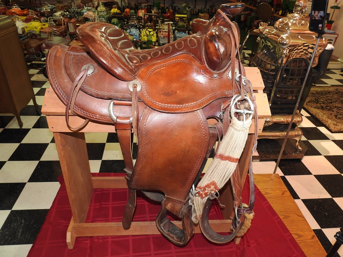 Big Horn Western Saddle with Stand: Vintage Big Horn western saddle with tooled leather, stirrups and display stand. Approx. 40 x 18 x 32 in. Gullet noted at approximately 13 in. Shows leather wear, scuffs, surface marks, patina and