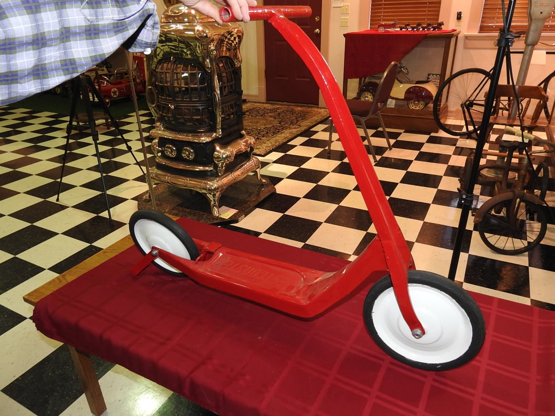 Restored Red WestCoaster Scooter: Vintage red WestCoaster scooter, restored, with white wheels, foot brake and curved handlebar. Approx. 32.5 x 12 x 40 in. Foot brake reported operational. Shows restoration/display wear, small