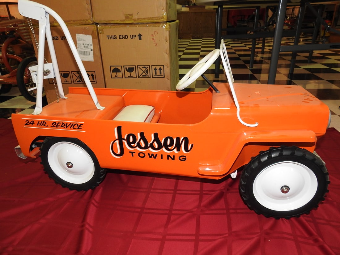 Jessen Towing Wrecker Pedal Truck: Vintage orange Jessen Towing wrecker pedal truck with removable seat and tow graphics. Approx. 27 x 16 x 42 in. Steering wheel is not operational per notes. Shows paint wear, scratches, oxidation,