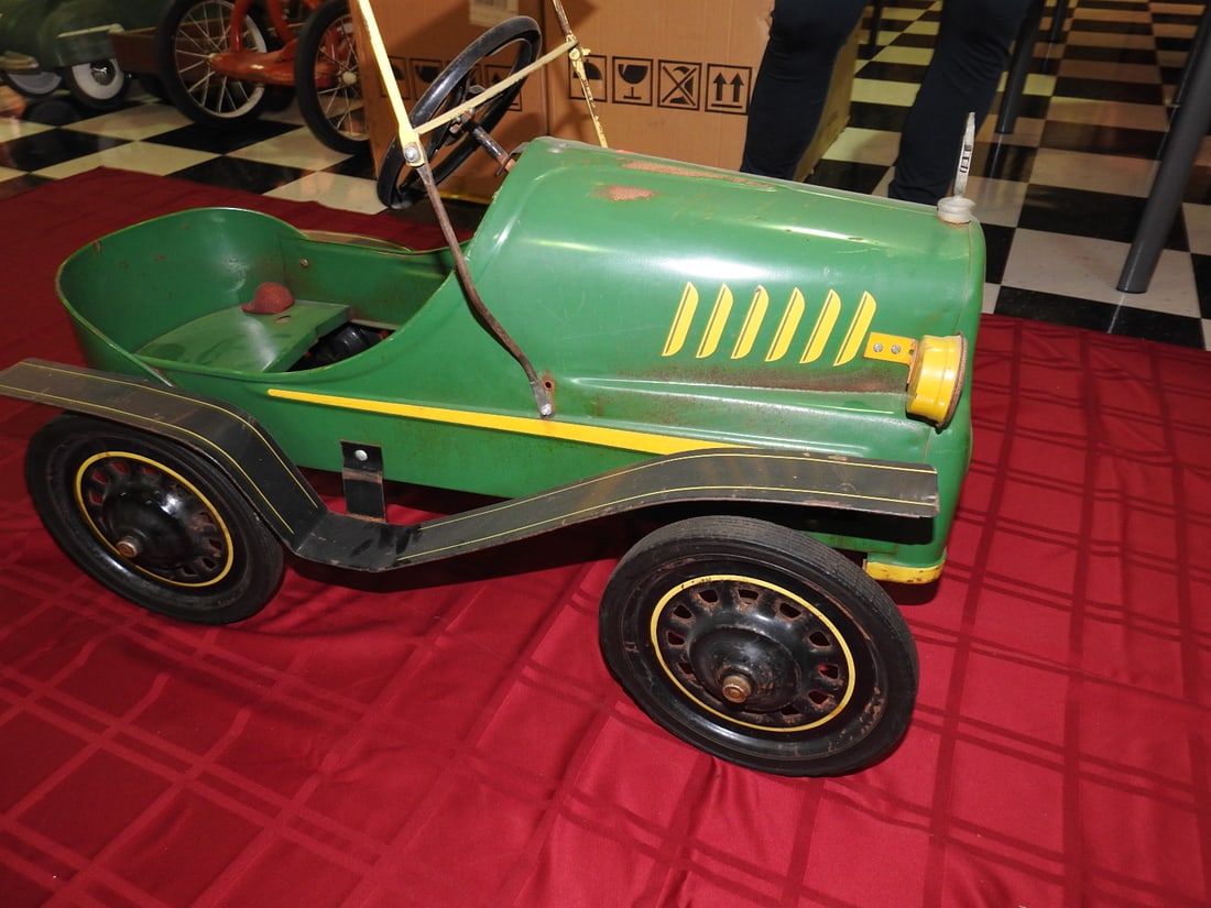 Garton Tin Lizzie with Broken Horn Bulb: Vintage Garton Tin Lizzie with green body and yellow wheels. Approx. 25 x 20 x 34 in. Horn bulb is broken per notes. Shows paint wear, oxidation, surface scratches, tire wear and age-related use wear.