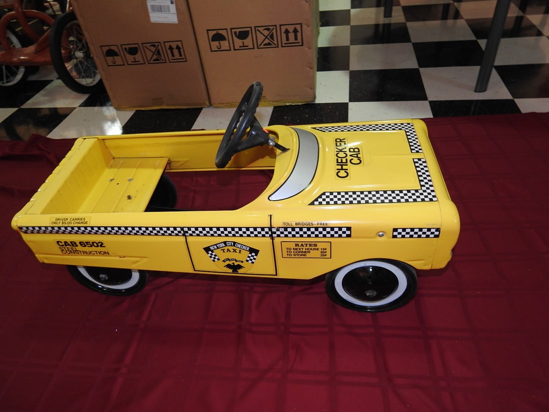 Roadmaster Checker Cab Pedal Car No. 6502: Vintage Roadmaster Checker Cab pedal car, cab No. 6502, in yellow cab graphics. Approx. 18 x 15 x 35 in. Shows paint wear, scratches, scuffs, tire wear and age-related use wear; see photos for