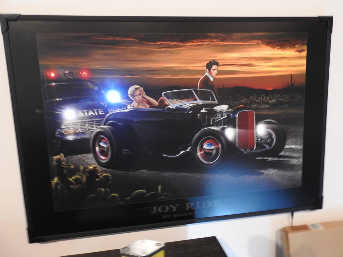 Helen Flint Joy Ride LED Marilyn Monroe & Elvis Print: Lighted Joy Ride artwork by Helen Flint featuring a classic roadster scene with Marilyn Monroe and Elvis Presley imagery. Approx. 24.5 x 36.5 x 1 in. Light function not fully tested unless shown in