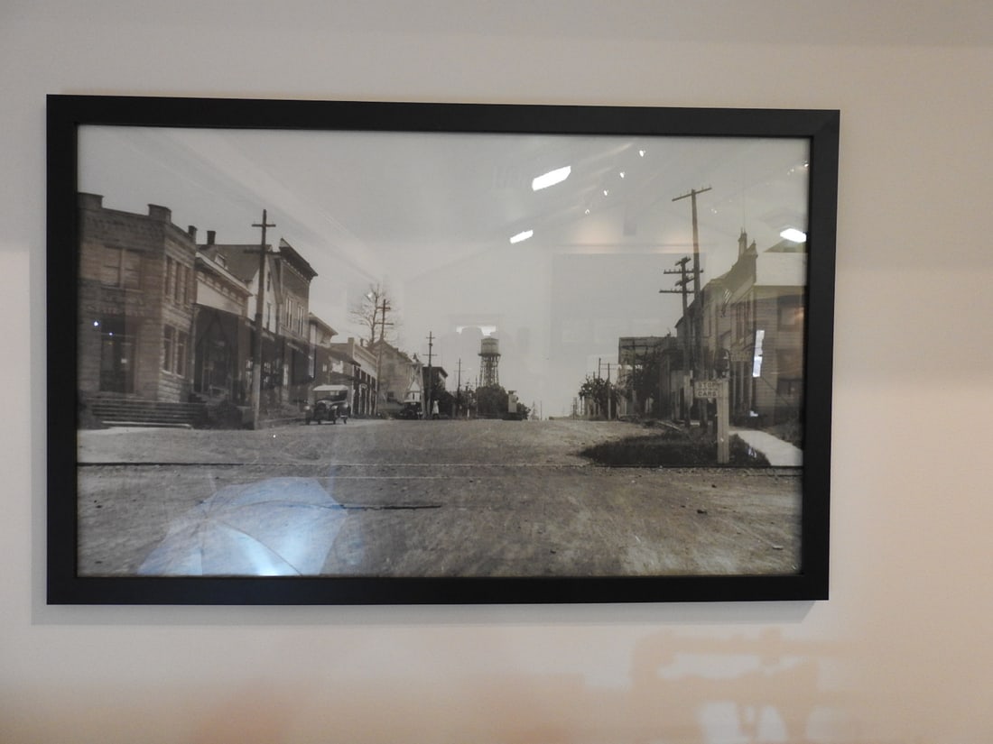 Framed Main Street Historical Photograph / Print: Large framed Main Street historical photograph/print with early streetscape subject matter. Approx. 27.5 x 38.5 x 1 in. Frame and print show age/display wear, surface marks, dust and backing wear;