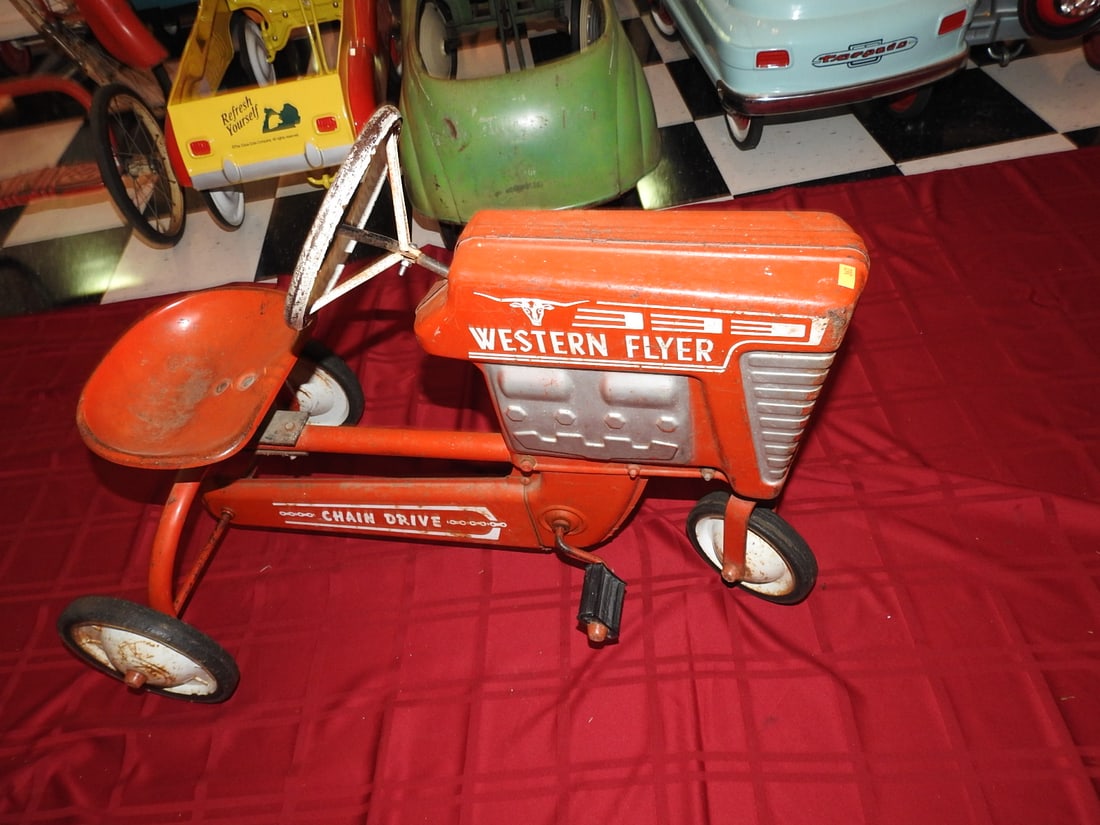 Western Flyer Chain Drive Pedal Tractor: Western Flyer chain drive pedal tractor with metal body, steering wheel, seat and pedal drive. Approx. 24 x 20 x 33 in. Shows age/use wear, paint loss, scratches, oxidation, tire wear and patina; see 