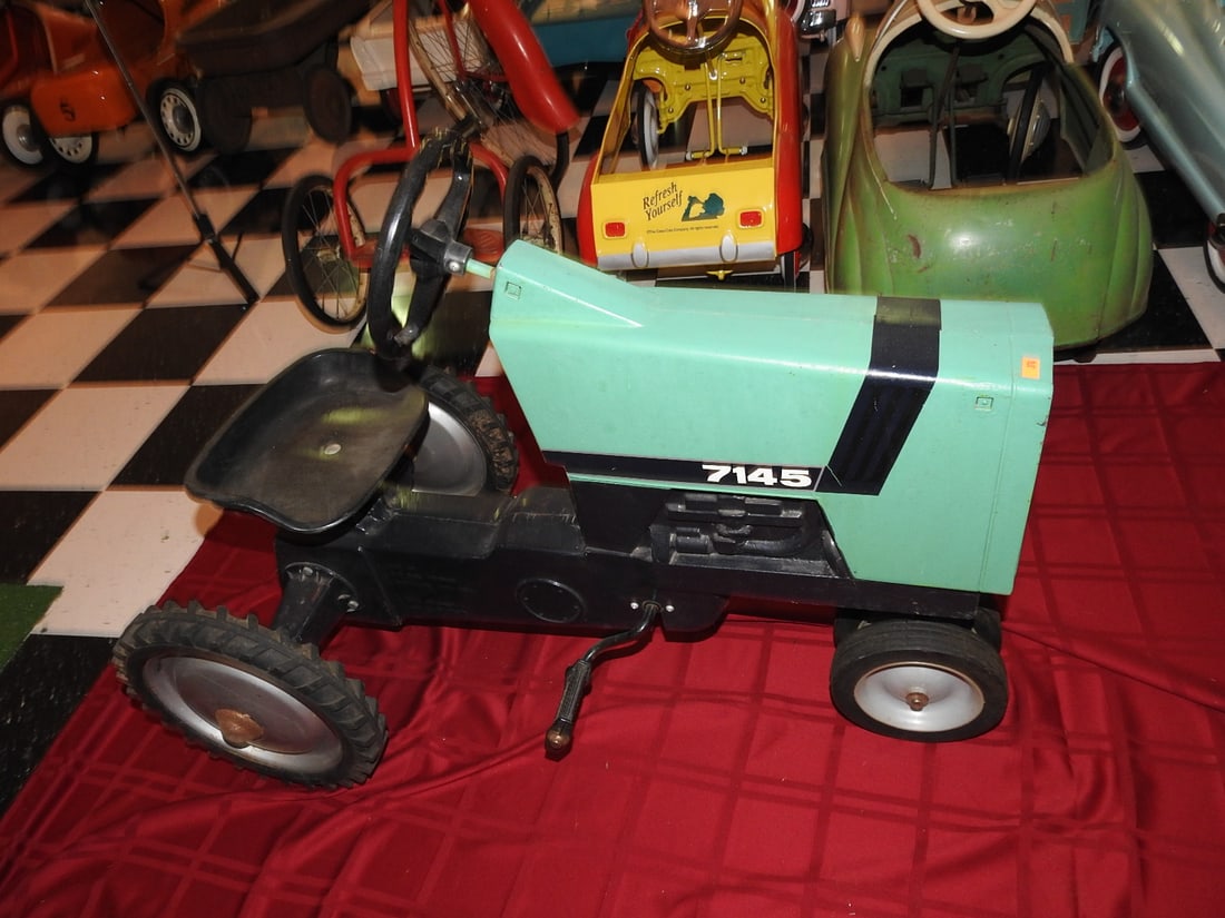 Deutz-Allis 7145 Pedal Tractor: Deutz-Allis 7145 pedal tractor with green styling, metal body, steering wheel, seat and pedal drive. Approx. 27.5 x 21 x 38 in. Shows age/use wear, paint loss, scratches, oxidation, tire wear and