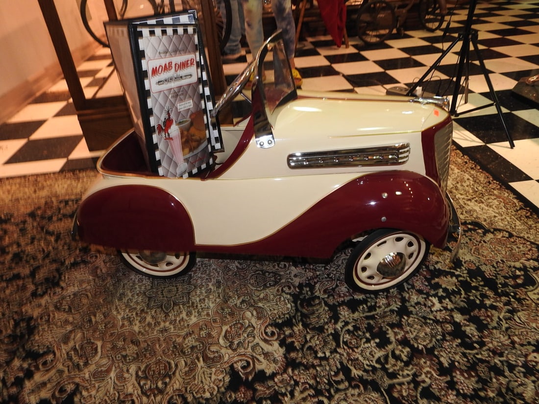 1939 Dodge Steelcraft M10 Pedal Car: 1939 Dodge Steelcraft M10 pedal car with green finish, metal body, steering wheel, windshield, seat and whitewall-style tires. Approx. 24 x 17 x 40 in. Shows age/display wear, paint marks, scratches,