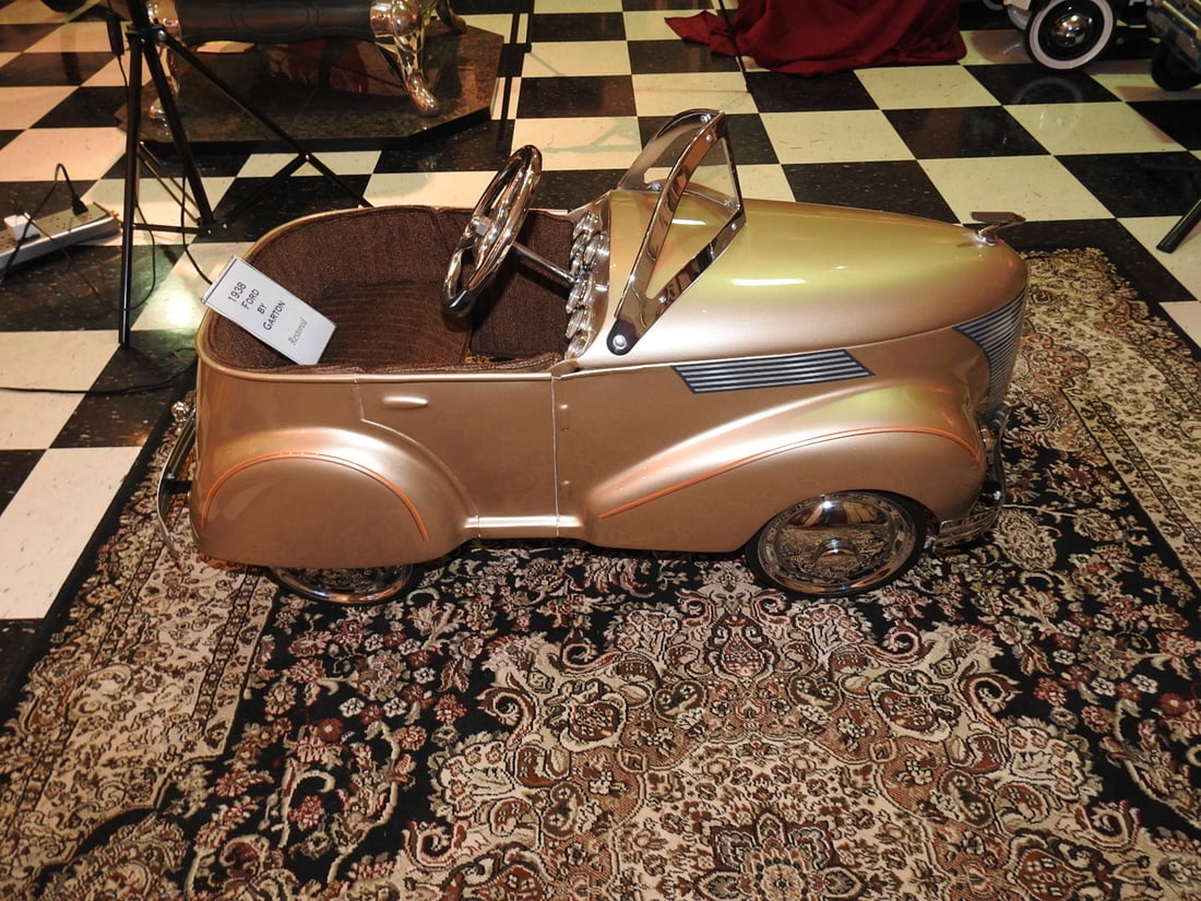 1938 Ford Garton Pedal Car: 1938 Ford by Garton pedal car with metal body, steering wheel, windshield, trim and whitewall-style tires. Approx. 21 x 17 x 38 in. Shows age/display wear, paint marks, scratches, oxidation, tire