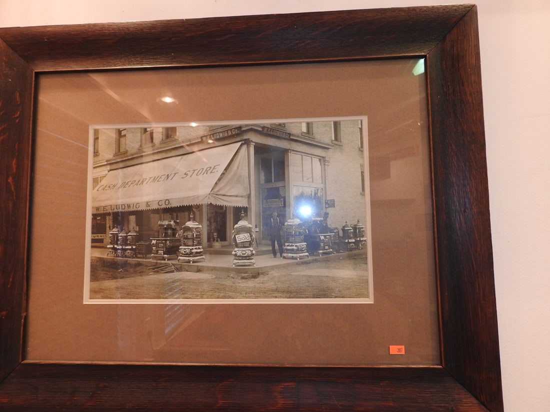 Framed Vintage Storefront Photograph: Framed vintage storefront photograph/print with historic commercial building subject matter. Approx. 23.5 x 30 x 1 in. Frame and print show age/display wear, surface marks, dust and backing wear; see