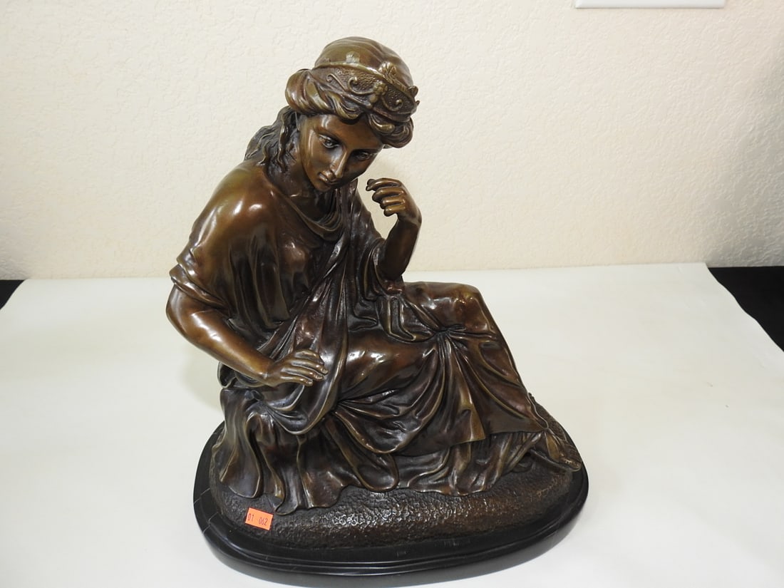 Bronze Young Woman Statue on Black Marble Base: Solid bronze statue of a young woman mounted on black marble base. Approx. 15 x 14 x 7.5 in.