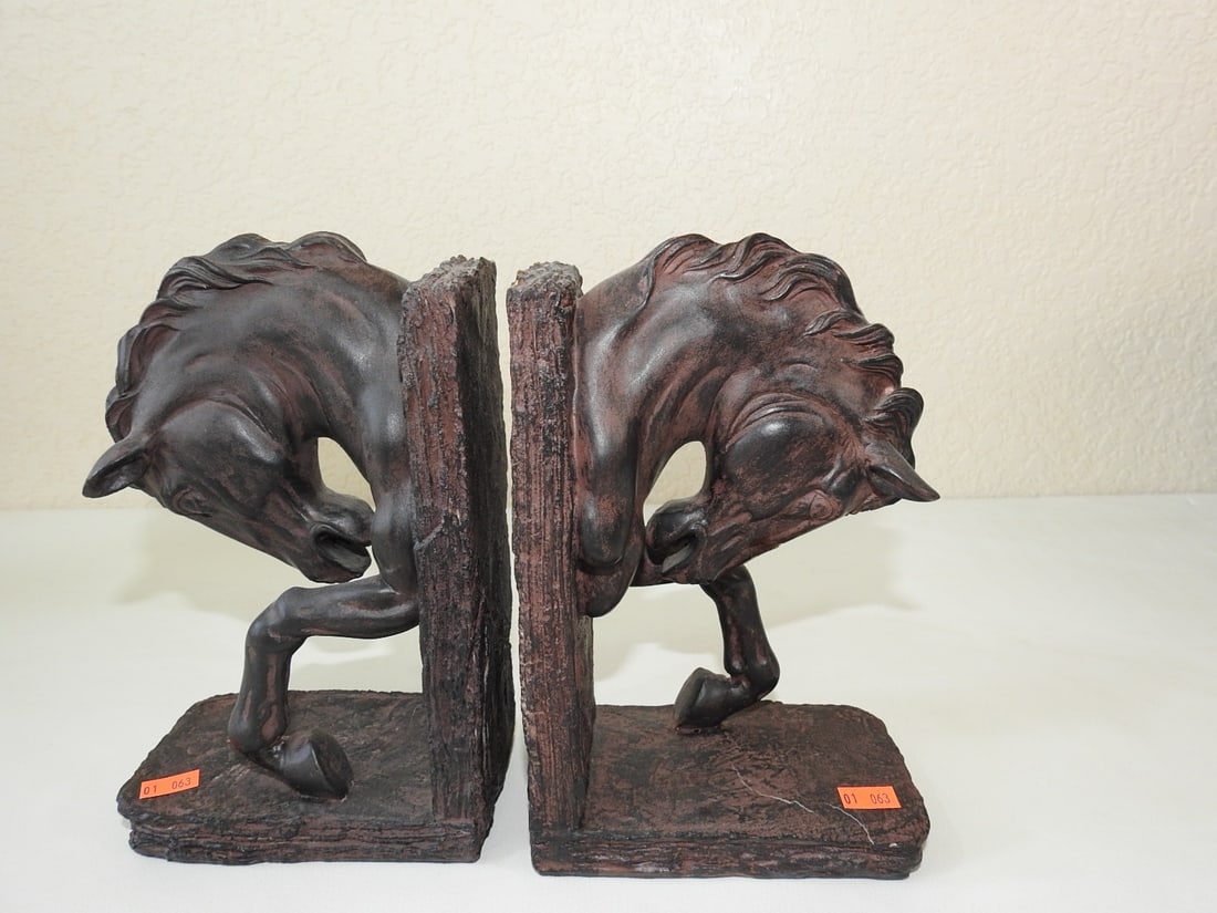Faux Bronze Horse Head Bookends Pair: Pair of faux bronze horse head bookends with textured bases. Approx. 9 x 7.5 x 6 in.