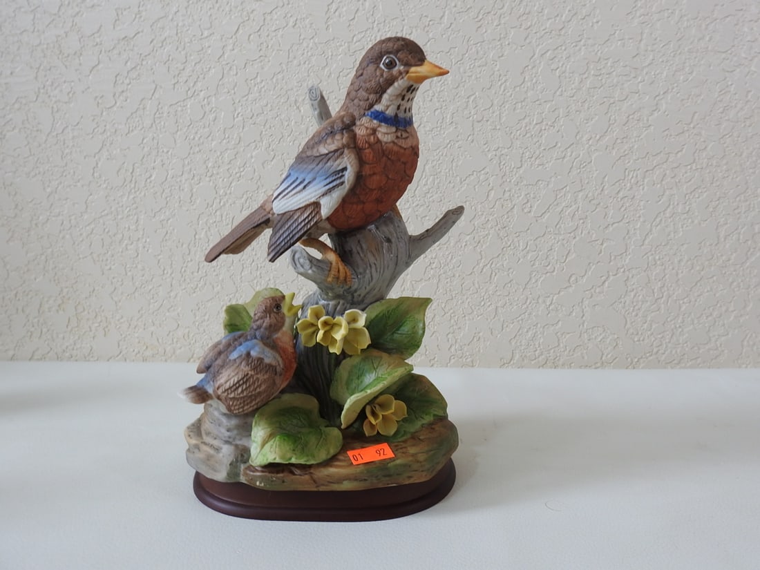 Vintage Porcelain Bird Figurine on Floral Base: Vintage porcelain bird figurine on floral branch base with wood display base. Maker not identified in notes. Approx. 9 x 6.5 x 4 in.