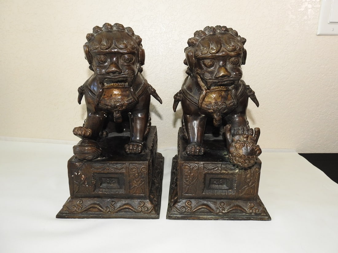 Pair of Bronze Chinese Fu Dog Statues: Pair of hollow bronze Chinese Fu Dog guardian lion statues, measured as a set. Approx. 13 x 7.5 x 11.5 in.