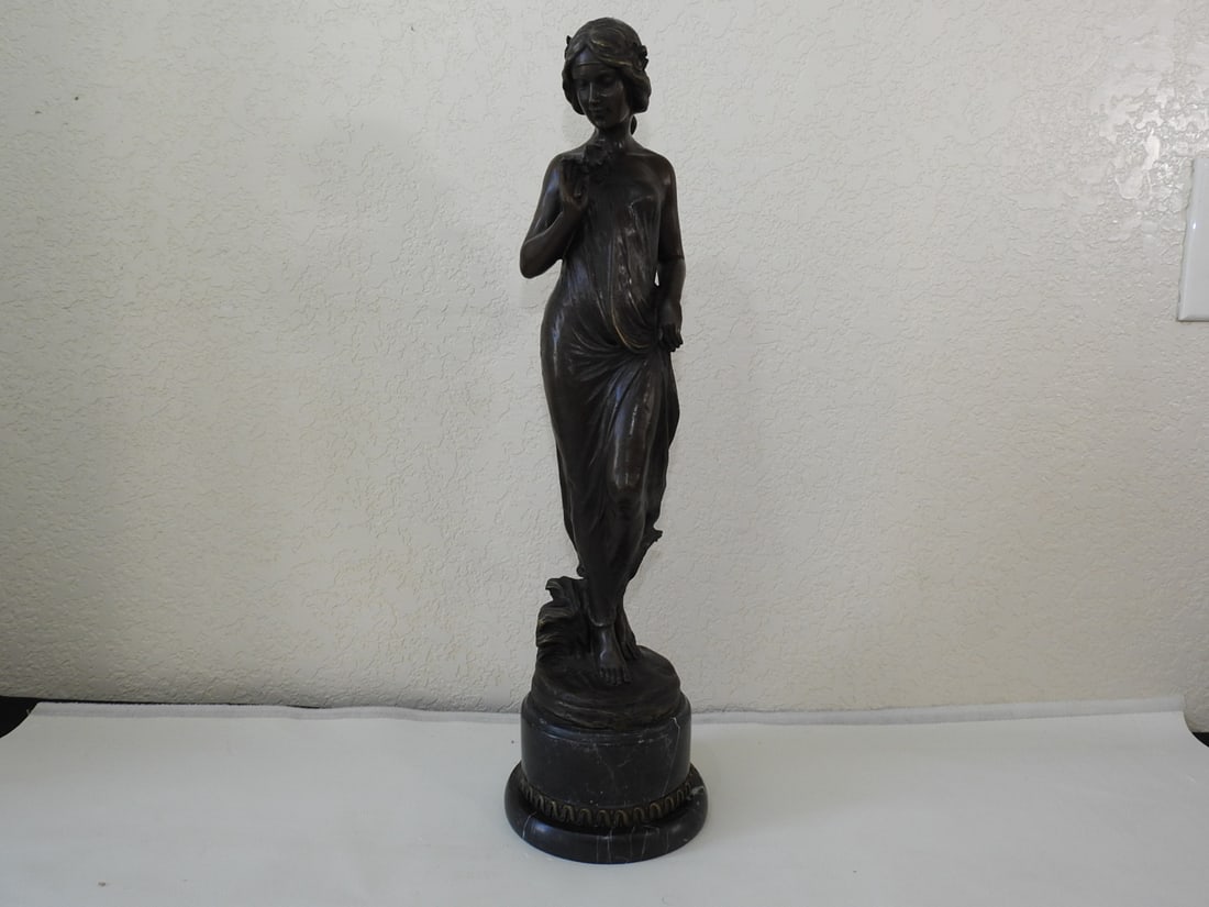 Art Nouveau Bronze Young Lady Statue: Art Nouveau style bronze statue of a young lady mounted on a black marble base. Approx. 21 x 6 x 6 in.