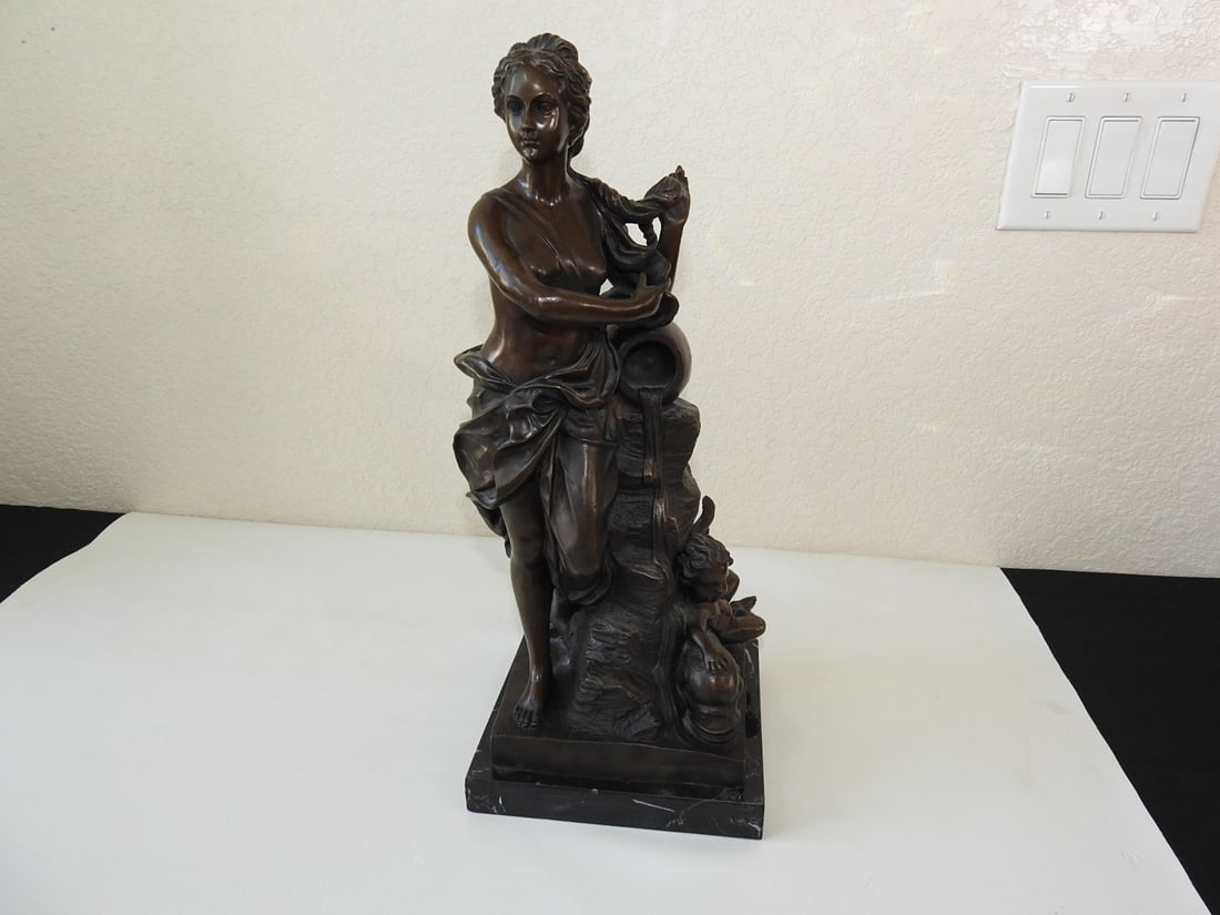 Bronze Venus and Cupid Statue on Marble Base: Bronze statue depicting Venus and Cupid, mounted on a black marble base. Approx. 20 x 17.75 x 7.5 in.