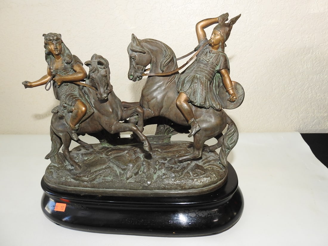 Greek Warrior Bronze Statue on Wooden Base: Solid hollow bronze Greek warrior statue with gold gilt and green patina accents, mounted on footed wooden base. Approx. 12 x 13 x 5 in.