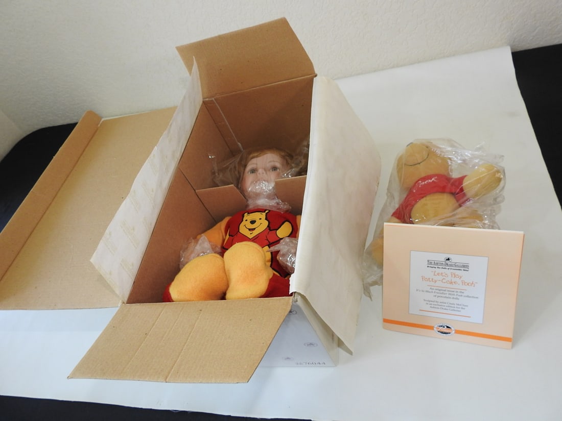 Ashton-Drake “Let’s Play Patty Cake?? Pooh Doll: Ashton-Drake Galleries “Let’s Play Patty Cake” Pooh doll, complete set with certificate of authenticity. Approx. 14 x 7.5 x 7.25 in.