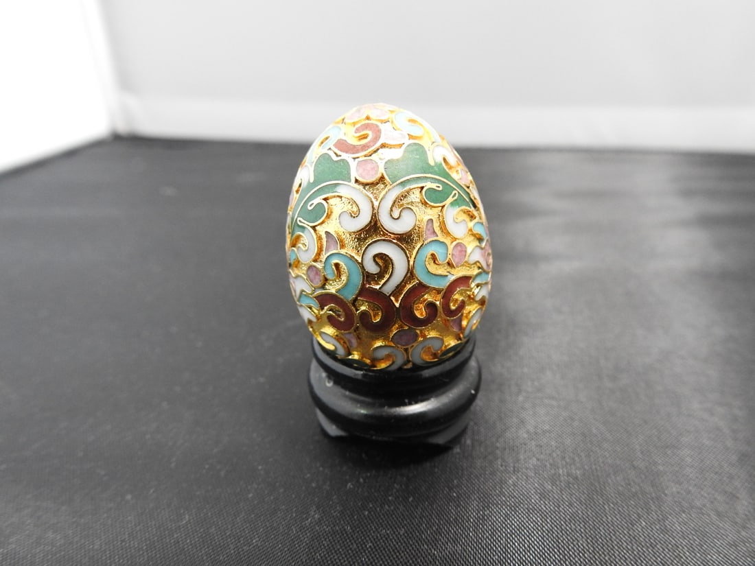 Small Vintage Chinese Cloisonne Egg on Wood Base: Small vintage Chinese cloisonne egg with gilt finish and custom fitted wooden base. Approx. 2 x 1.5 x 1.5 in.