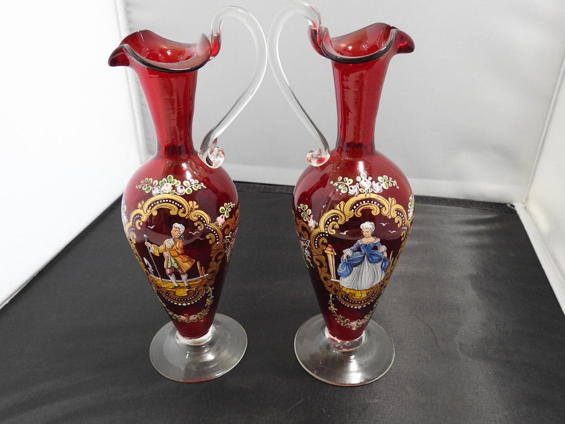 Pair of Neoclassical Hand-Blown Ruby Glass Vases: Pair of neoclassical style hand-blown glass vases with ruby glass, gold gilt, hand-painted decoration, and applied handles. Approx. 8.5 x 5.5 x 3 in.