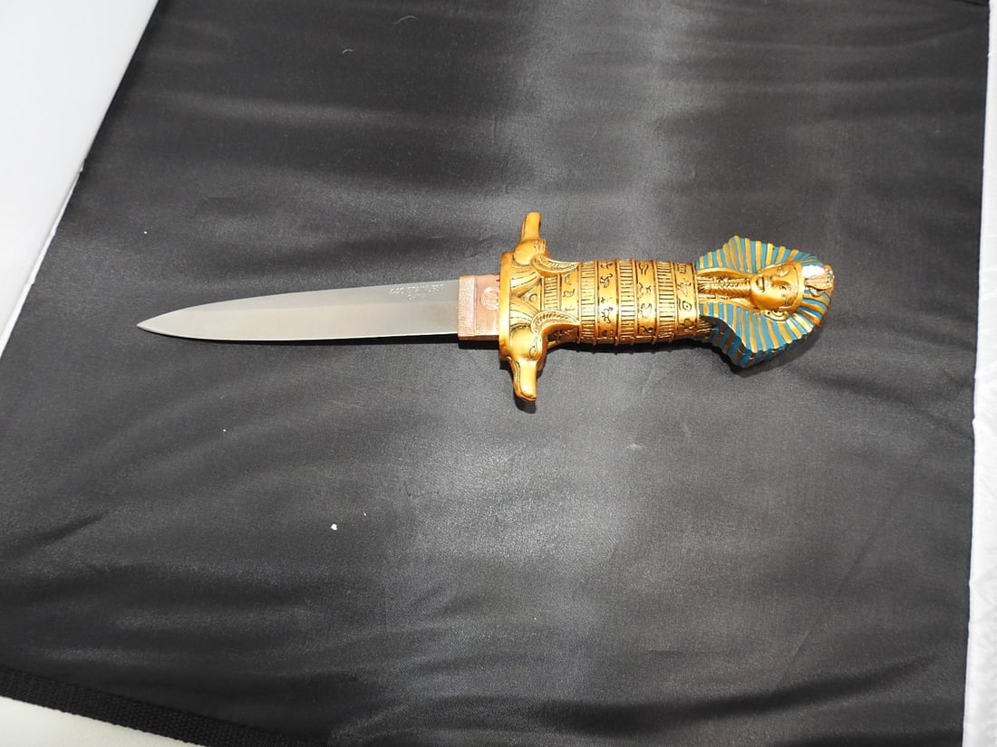Egyptian Ceremonial Dagger with King Tut Handle: Egyptian ceremonial dagger with resin handle depicting King Tut, stainless steel #440 blade, and chipped snake detail noted; see photos. Approx. 11.5 x 3.5 x 2 in.