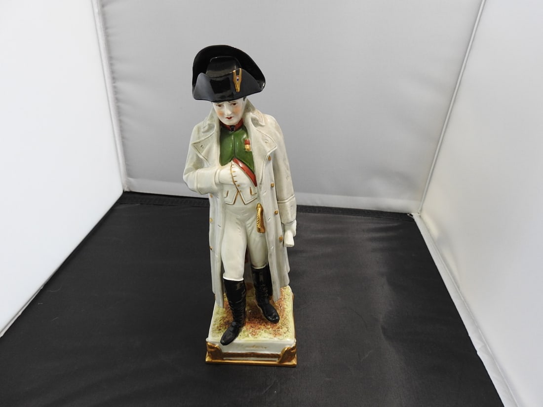 Scheibe-Alsbach Napoleon German Porcelain Figure: Scheibe-Alsbach German porcelain Napoleon figure with gold gilt accents and commemorative information on bottom, #12753/12. Approx. 9.5 x 3.5 x 3.5 in.