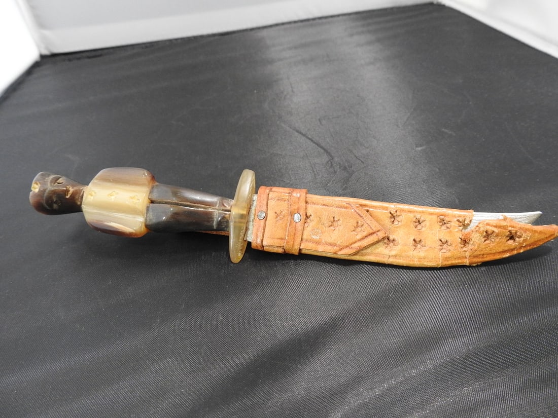 Guatemalan Handmade Knife with Horn Figural Handle: Guatemalan handmade knife with leather sheath, carved figural horn handle, and handmade blade. Approx. 7.5 x 1.5 x 1 in.