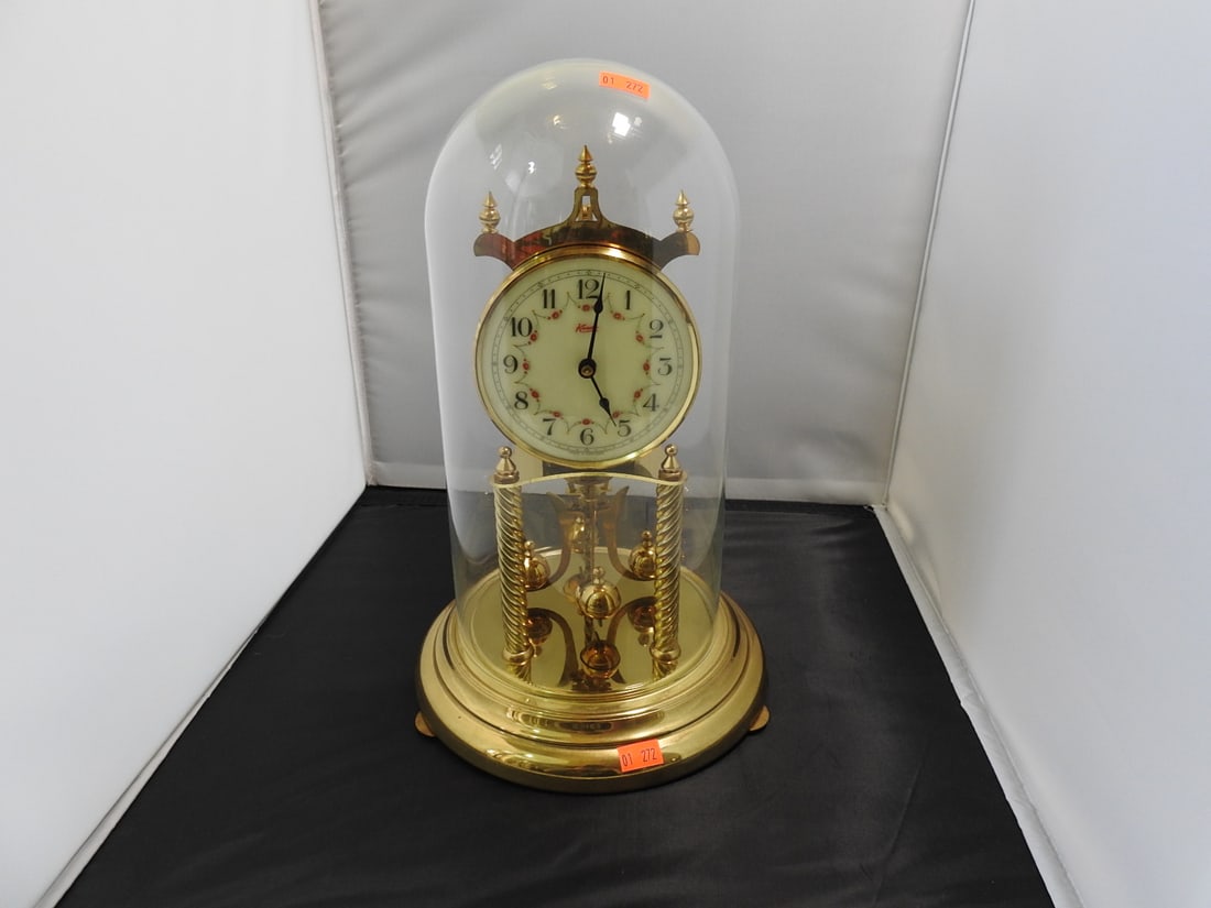 Kundo Kieninger & Obergfell 400-Day Anniversary Clock: Kundo 400-day anniversary clock by Kieninger & Obergfell with glass dome/case, brass-tone rotating pendulum/carousel movement, plastic base, and Westminster chiming movement. Movement marked Kieninger