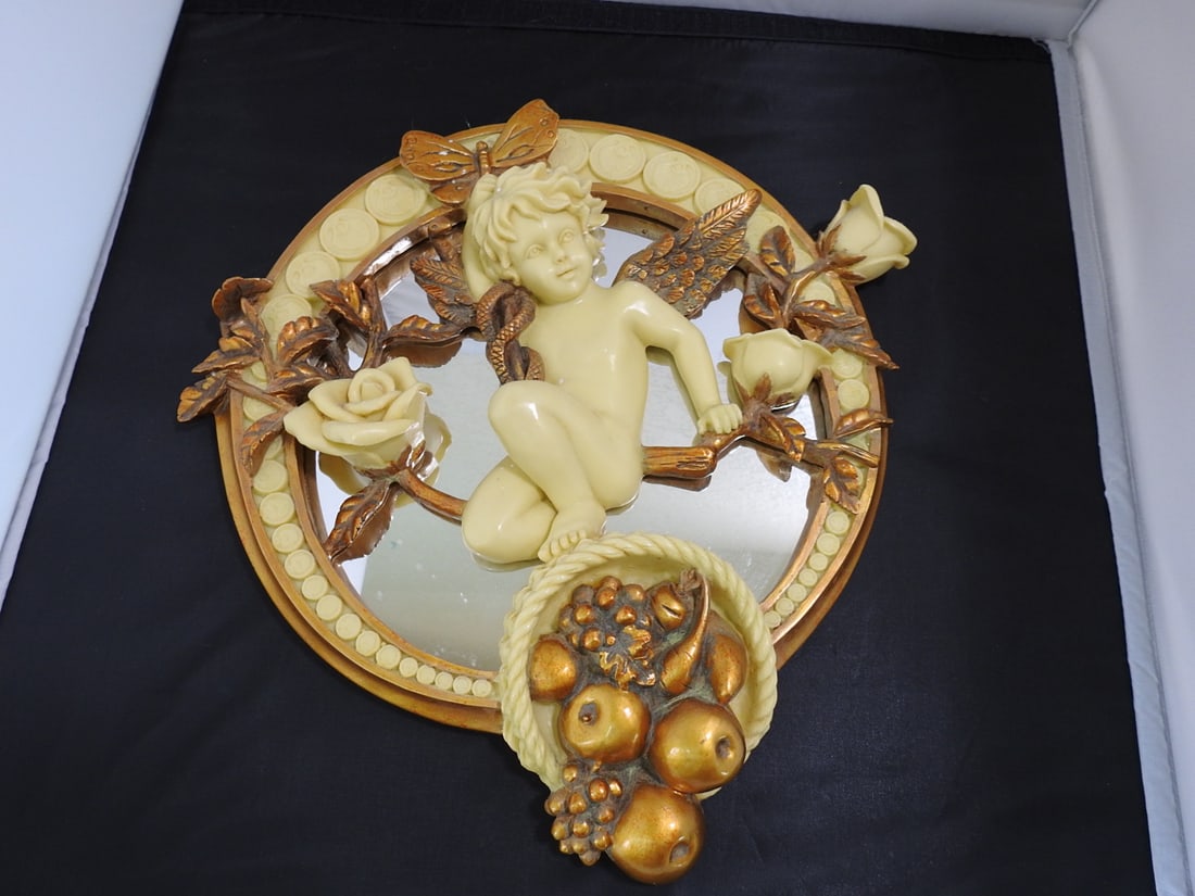 Faux Bone Cherub Mirror: Faux Bone Cherub Mirror. Cut-work design, rich gold accents, heavy resin Approx. 12 x 11.5 x 2.5 in.