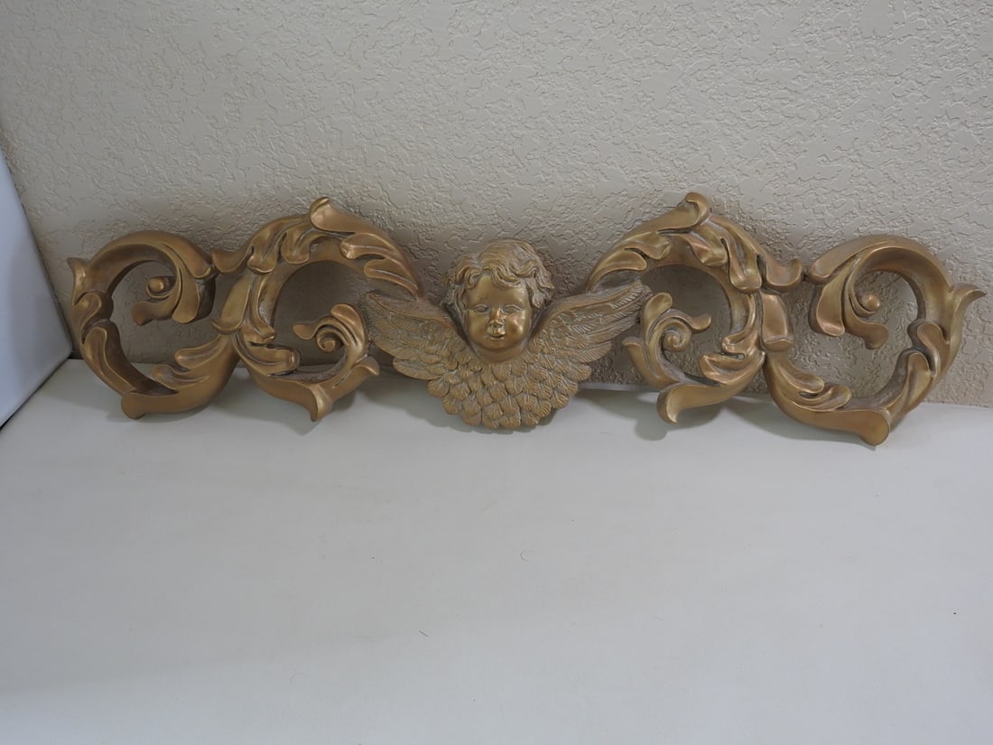 Victorian Style Cherub Wall Flourish: Victorian style cherub wall flourish in painted gold hard resin. Approx. 8.5 x 30 x 2.5 in.