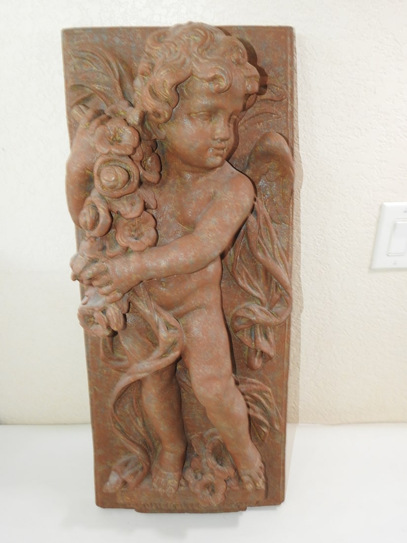 Cherub Wall Plaque: Cherub Wall Plaque. Faux rusted Tin, hollowed tin, back is particle board Approx. 29 x 12.5 x 6.5 in.