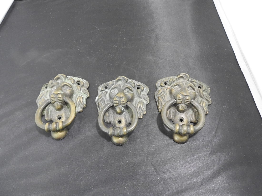Set of Three Vintage Cast Brass Lion Head Drawer Pulls: Set of three vintage cast brass lion head drawer pulls with ring pulls and classical European styling. Natural oxidation/aged patina. Approx. 3 x 4.25 x 3 in.