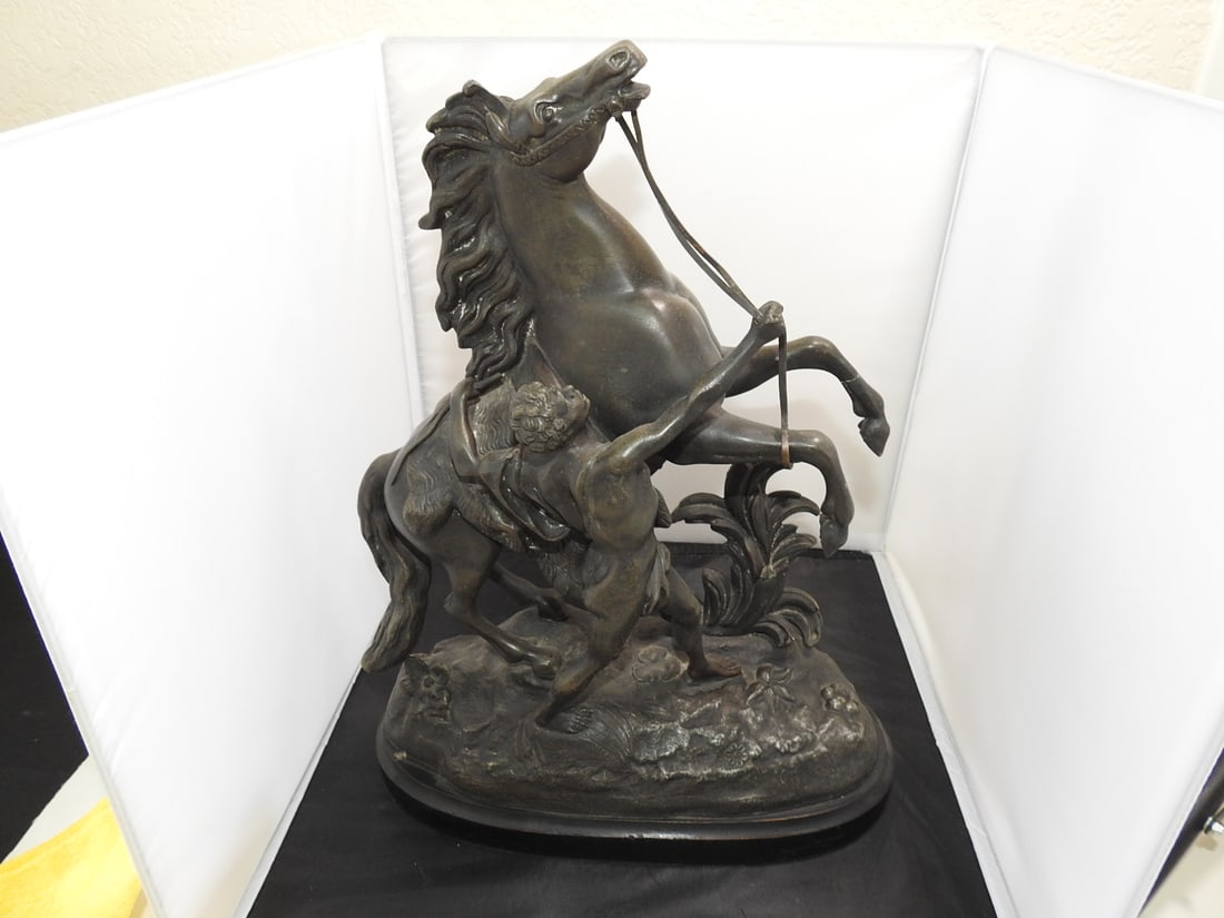 Marly Horses Faux Bronze Sculpture After Guillaume Coustou: Marly Horses cast metal sculpture with faux bronze wash on marble base, after the original 1745 works by Guillaume Coustou. Repair noted; see photos. Approx. 16.75 x 13 x 6.5 in.