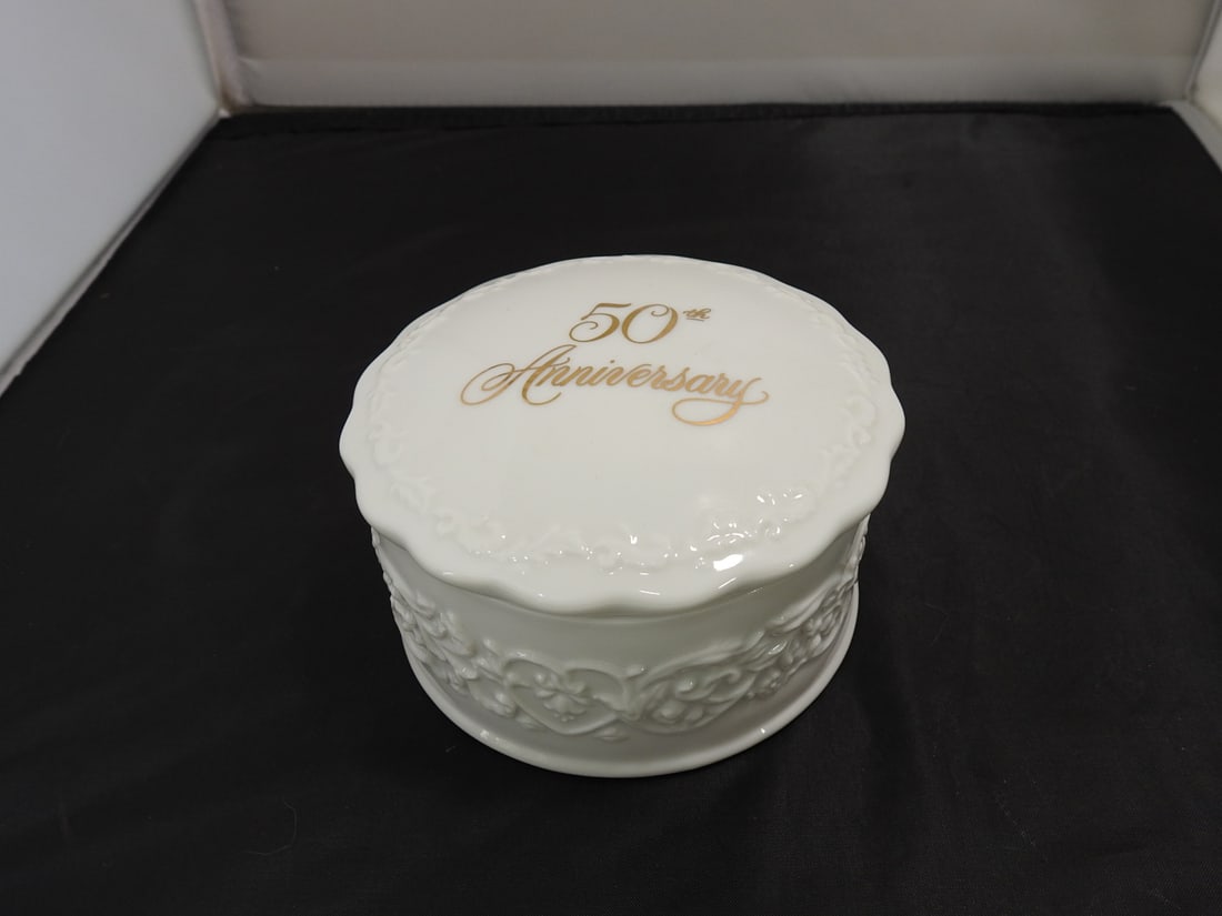 Hallmark 50th Anniversary Porcelain Music Box: Hallmark Cards 50th Anniversary porcelain music box/trinket box with white floral relief decoration and gold lettering. Serial no. AGA7212; plays per notes. Approx. 3.25 x 5 x 5 in.