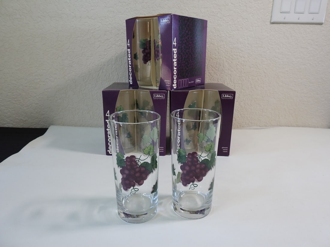 Lot of Three Boxed Libbey Decorated Drinking Glass Sets: Lot of three boxed sets of four Libbey decorated drinking glasses, new in box. Measured as a group. Approx. 14 x 14 x 8 in.