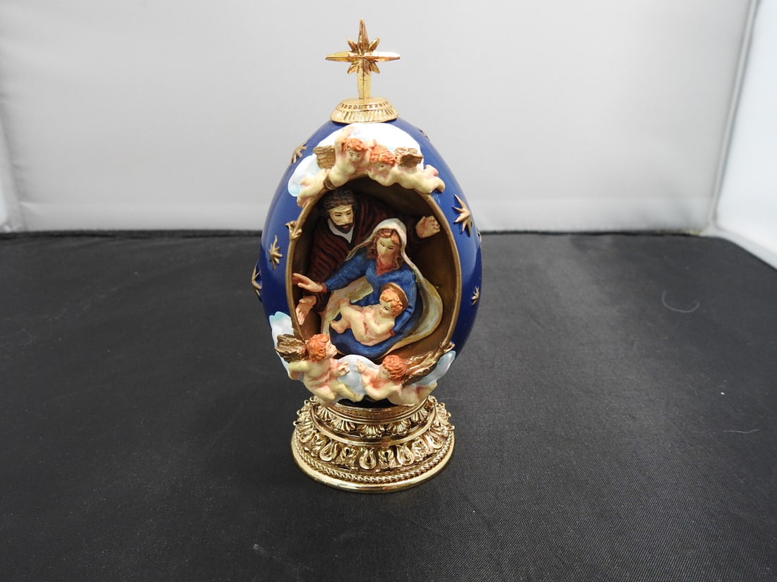 House of Faberge Holy Family Egg Figurine: House of Faberge Holy Family faux Faberge egg figurine, RTU3796, with hand-painted resin scene and gold-plated metal fixtures. Approx. 5 x 3 x 2.75 in.