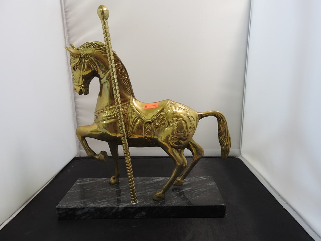 Solid Brass Carousel Horse on Black Marble Base: Solid brass carousel horse statue mounted on a black marble base, featuring raised decorative saddle and pole details. Approx. 12 x 11 x 4.5 in.