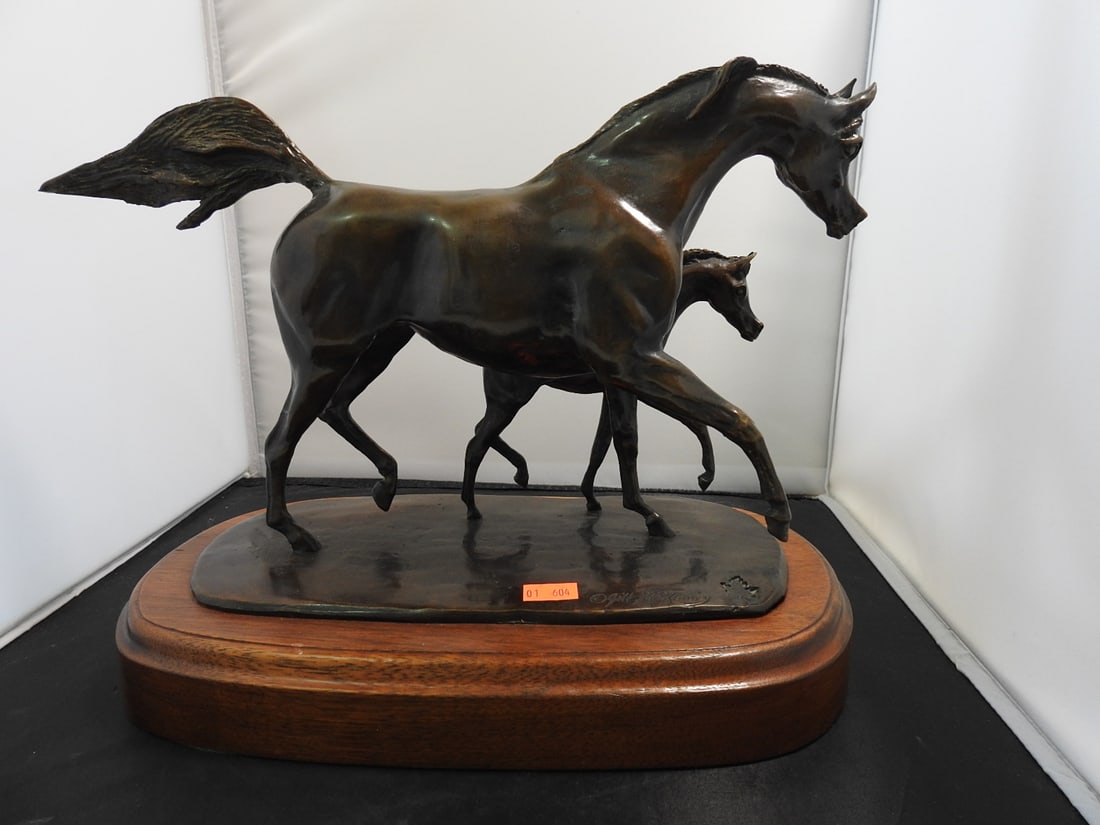 Jill M. Kinney Bronze Mare and Foal Statue on Wood Base: Bronze horse and young horse / mare and foal statue by Jill M. Kinney, mounted on a raised wooden base. Approx. 10 x 13.75 x 7.5 in.