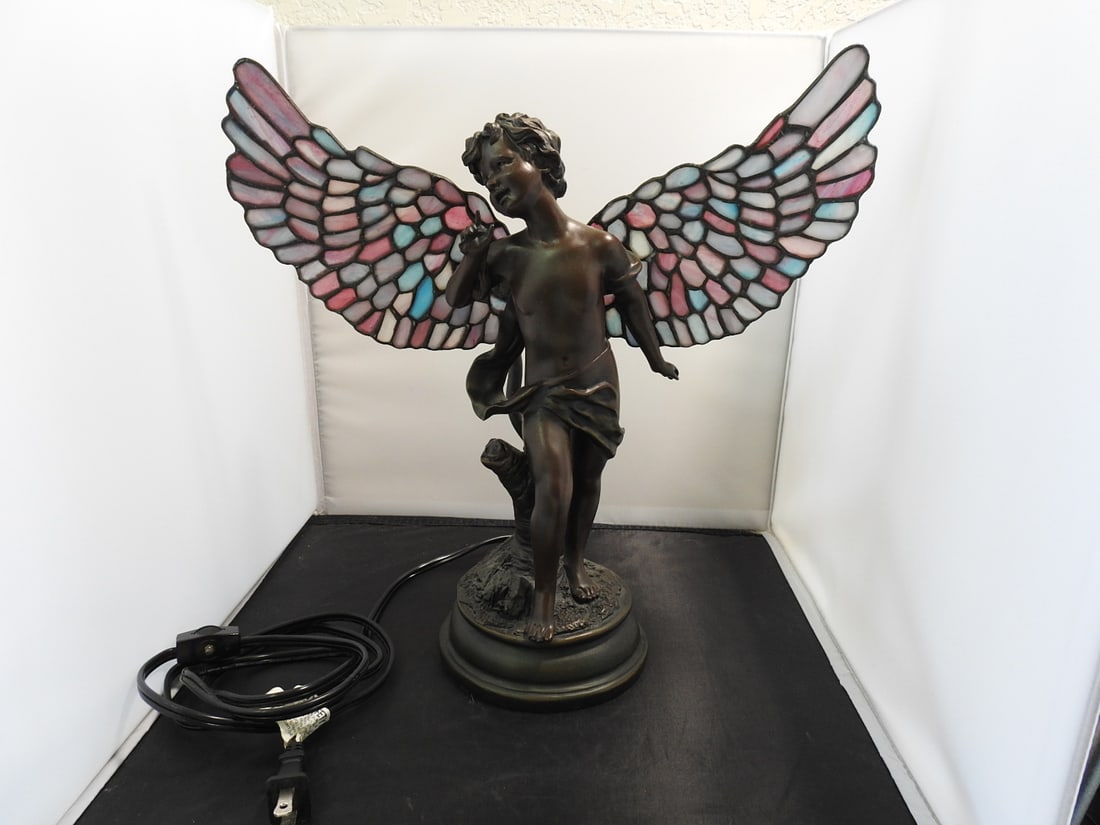 Art Nouveau Style Figural Cherub Table Lamp: Art Nouveau style figural cherub table lamp in faux bronze hard resin with stained glass style wings and round base. Made in China. Approx. 14 x 15 x 6.5 in.