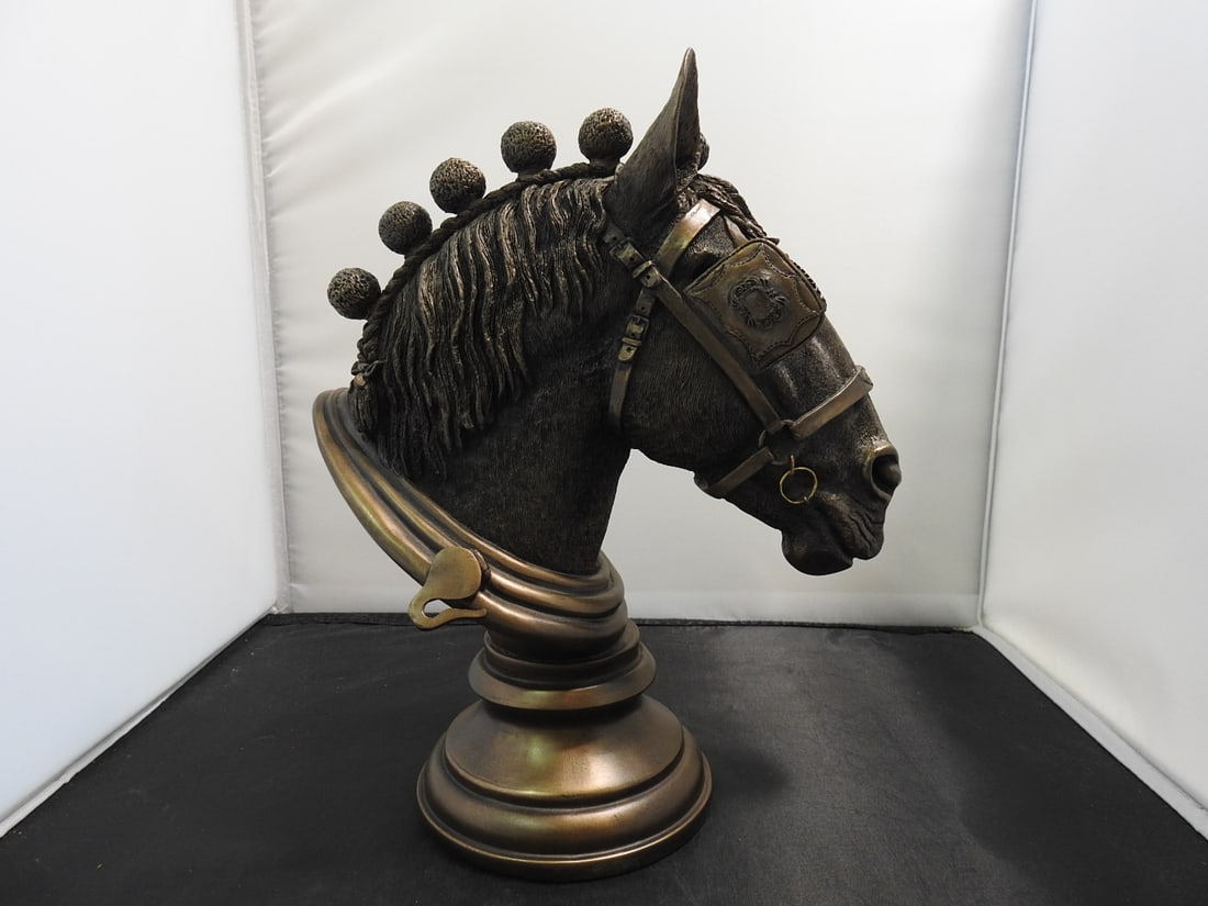 Faux Bronze Horse Head Bust: Faux bronze horse head bust in solid hard resin with decorative mane and pedestal-style base. Has a small break as shown. Approx. 10 x 8.5 x 5 in.