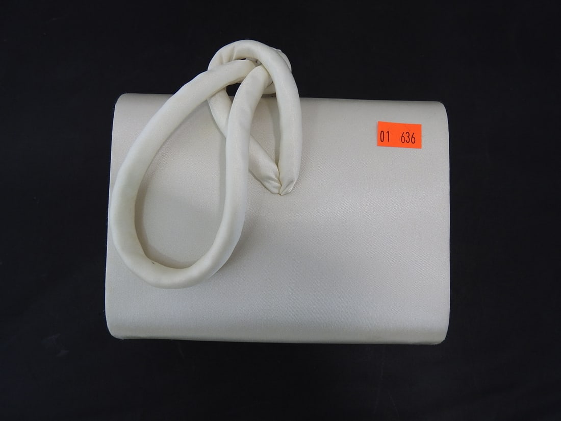 Valerie Stevens White Satin Clutch Bag: Valerie Stevens white satin clutch bag with sculptural handle. Appears unused, with age-related staining. Approx. 6 x 6.25 x 2.25 in.