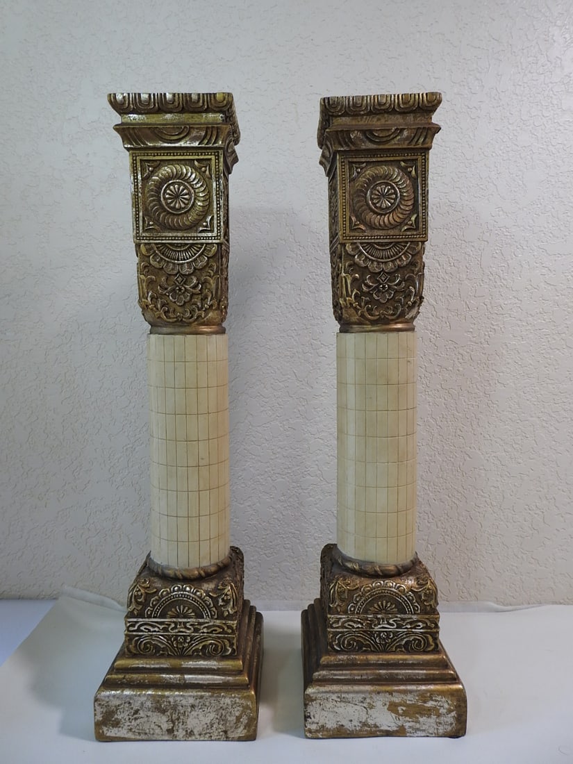 Pair of Roman Style Faux Bronze Pillar Candlesticks: Pair of Roman style faux bronze pillar candlesticks with acanthus leaf detail and classical decorative bases. Approx. 12.5 x 9.5 x 5 in.