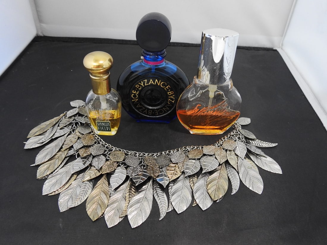 Lot of Perfume Bottles and Necklaces: Lot of assorted perfume bottles and necklaces displayed on decorative tray. Measured as packed. Approx. 4.5 x 3.5 x 5 in.