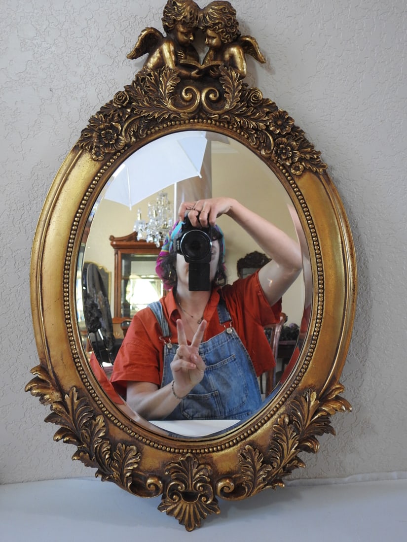 Victorian Style Gold Framed Pebbled Mirror: Victorian style mirror with fully encased wood frame, antiqued gold finish, ornate raised decoration, and pebbled mirror glass. Approx. 26.5 x 17 x 3 in.