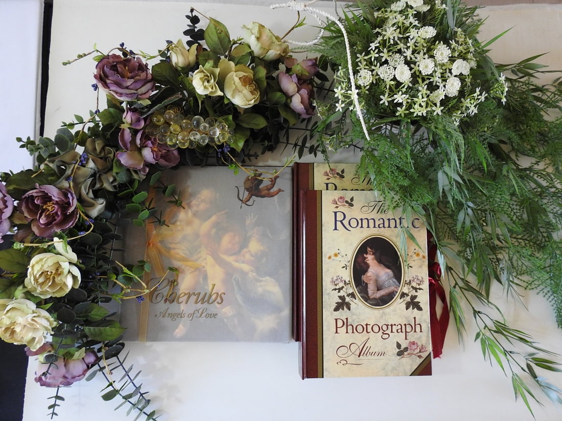 Instant Home Decor Collection with Silk Flower Swag & Albums: Instant home decor collection including silk flower swag, artificial plant decor, two Victorian romance photo albums, and cherubs and angels themed book of love decor. Measured as a group. Approx. 12 