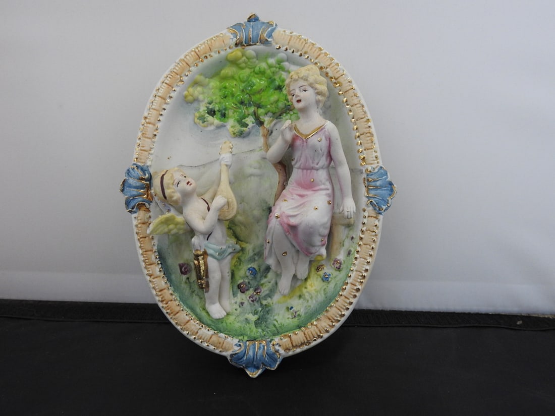 Vintage German Style Hand-Painted Wall Plaque: Vintage German style hand-painted wall plaque with pastoral figural scene, raised decoration, and gold accents. Marked Japan. Approx. 2.25 x 8 x 6.25 in.