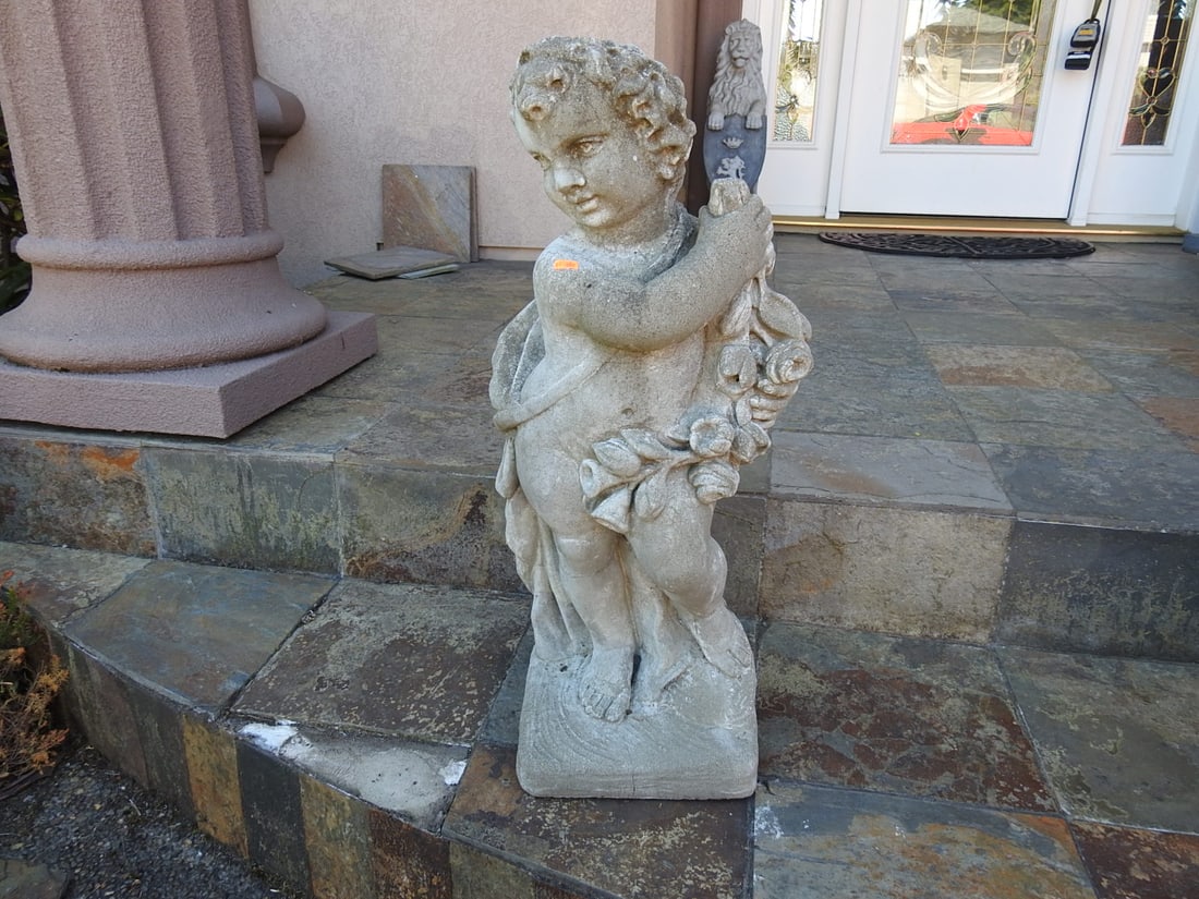 Classical Baroque Style Garden Putto Statue: Classical Baroque style garden statue depicting a standing putto / child figure with grapes and drapery. Minor cracks noted. Approx. 28.5 x 12.75 x 10.5 in.
