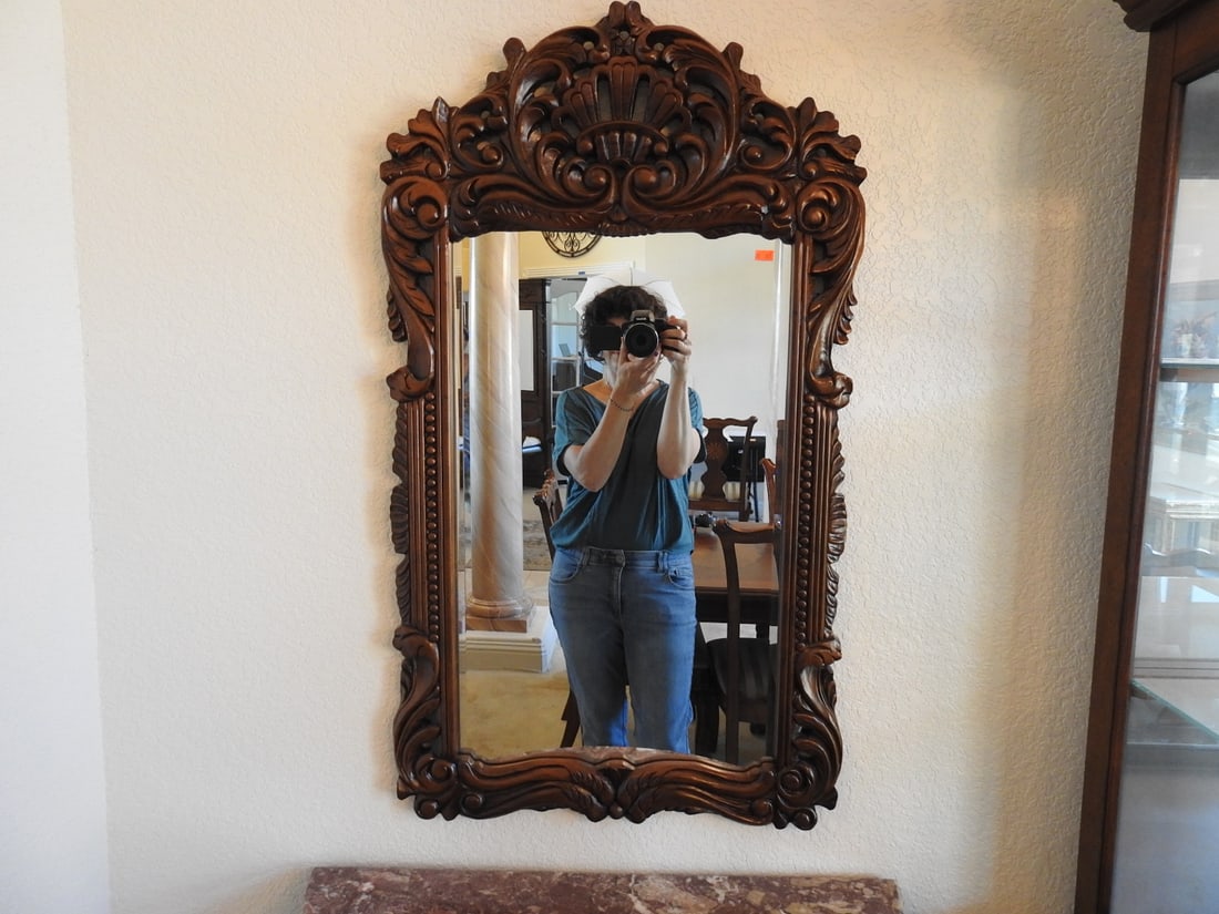 Rococo Style Carved Mahogany Wall Mirror: Rococo style carved mahogany wall mirror with ornate scroll, foliate, and shell-form crest decoration. Approx. 38.25 x 23 x 1.5 in.