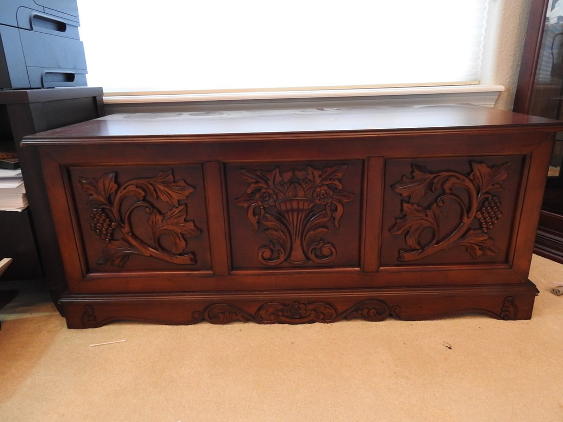 Carved Wooden Hope Chest: Carved wooden hope chest with hinged lid, paneled front, and carved floral / foliate decoration. Approx. 18.5 x 44.5 x 19.75 in.