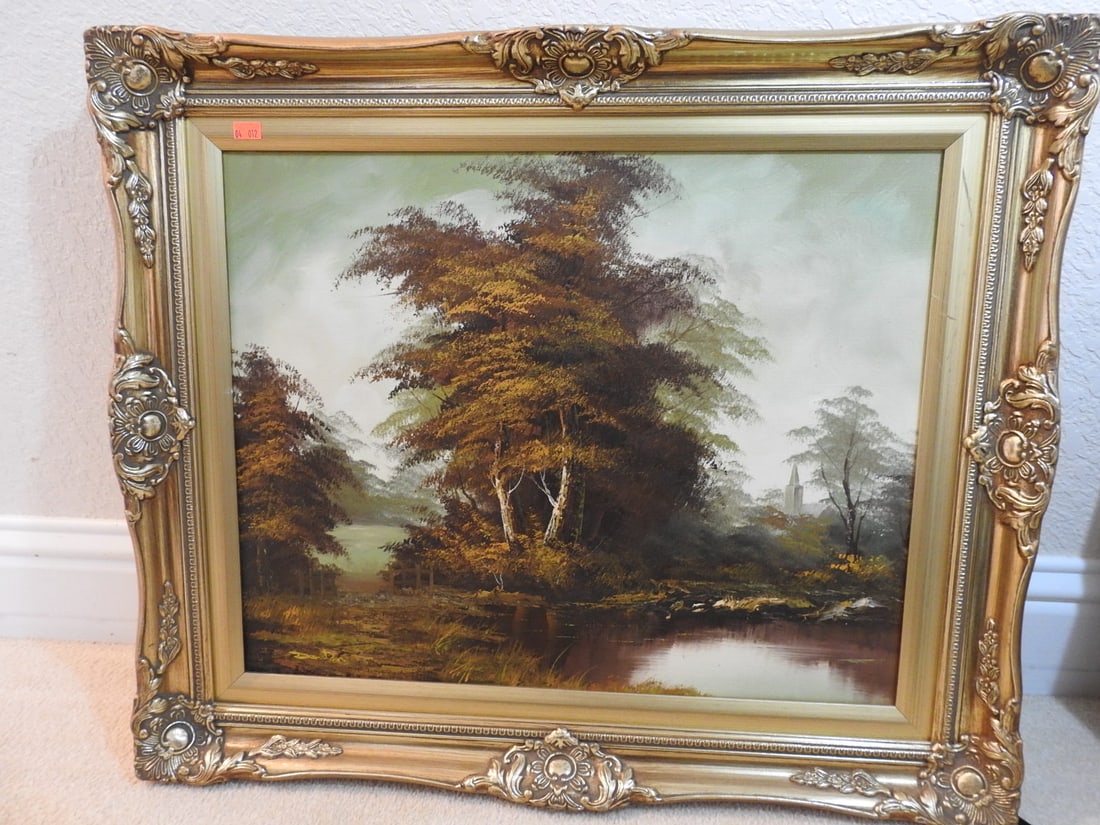 Framed Landscape Painting in Ornate Gilt Frame: Framed landscape painting depicting trees and water in an ornate gilt frame. Approx. 21.25 x 25.25 x 2 in.