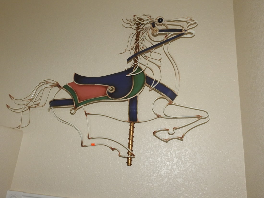 Painted Rocking Metal Carousel Horse Wall Plaque: Decorative painted metal carousel horse wall plaque in classic old-world style with colorful saddle and flowing mane/tail detail. Approx. 35 x 48 x 6 in.