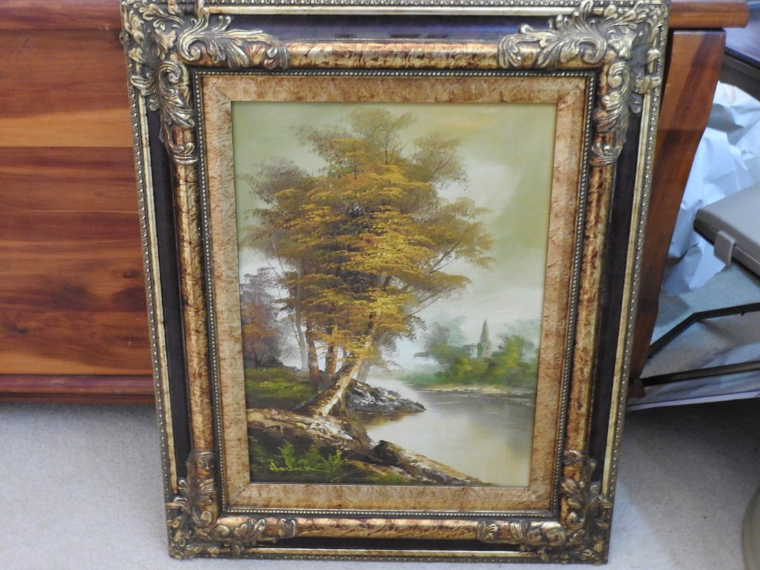 Framed Landscape Oil on Canvas: Framed landscape oil on canvas depicting a wooded stream and countryside scene. Approx. 23.5 x 19 x 2.5 in.